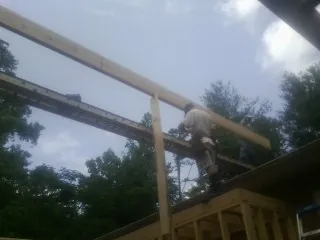 Carpenter setting a ridge beam over a new addition frame — Ice Dam Removal by Roofing Brothers in Egypt